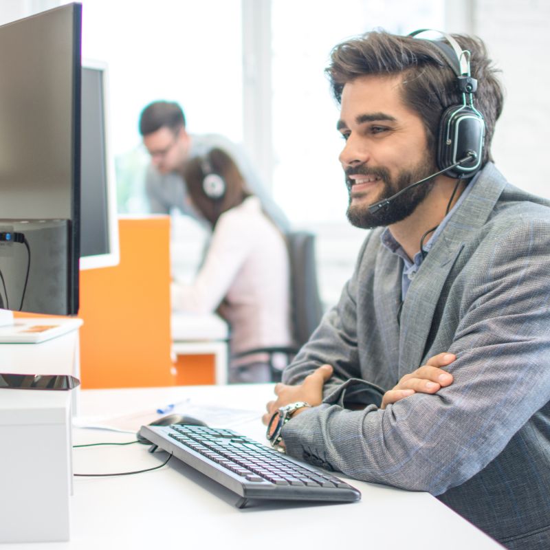 Office worker wearing a headset while working at a computer