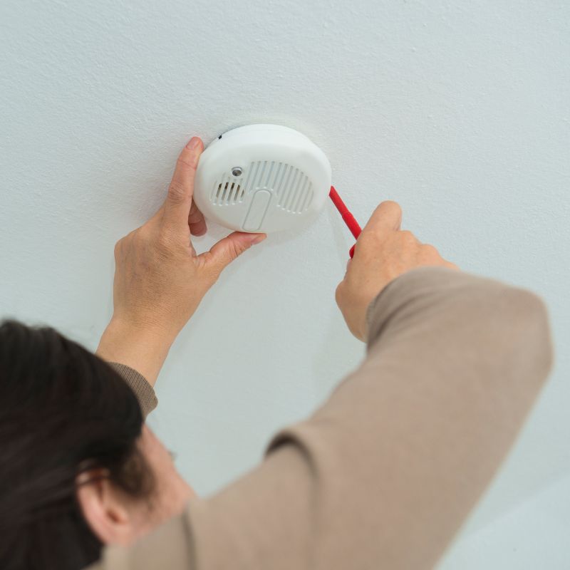 Technician installing a smoke detector