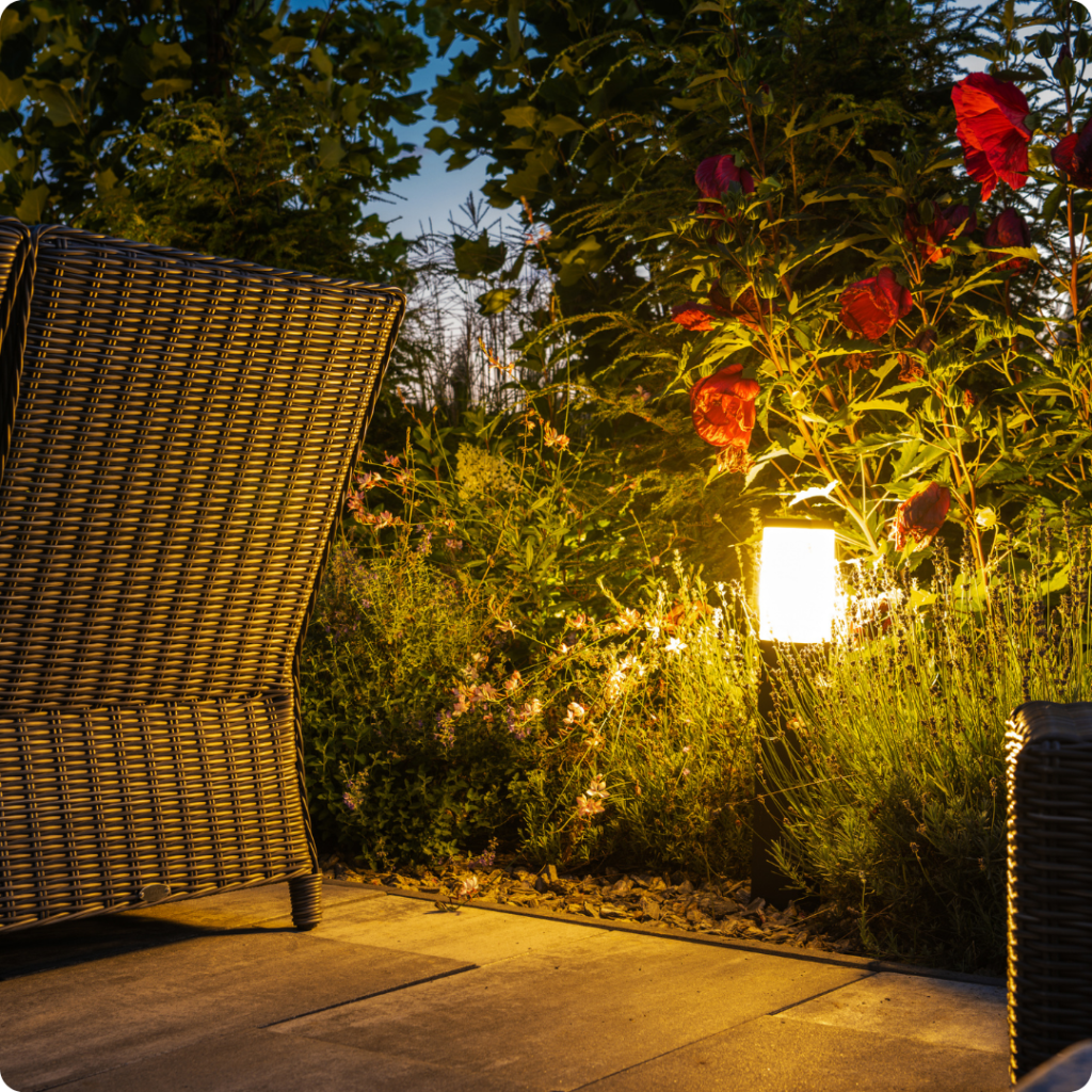 Subtle outdoor landscape lighting nestled in bushes, illuminating the yard


