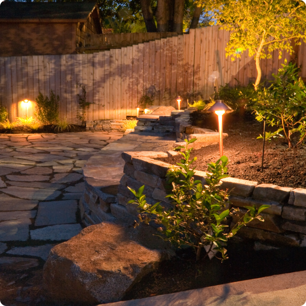 Accent lighting drawing attention to the garden, creating a focal point and enhancing the yard's visual appeal