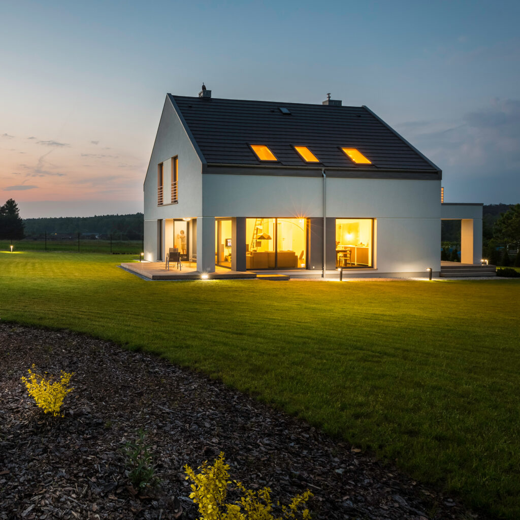  External view of stylish and modern house with outdoor lights at night