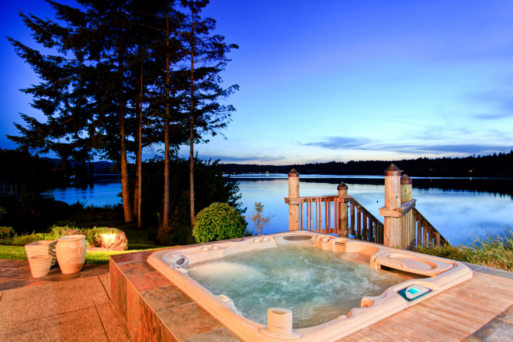 jacuzzi sitting on a deck overlooking a lake