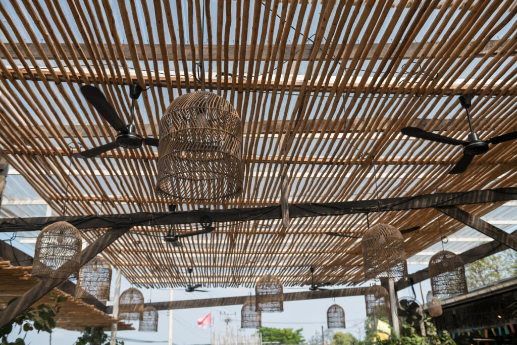 Many rattan lamps with electric fan hanging on bamboo ceiling. Outdoor restaurant decoration